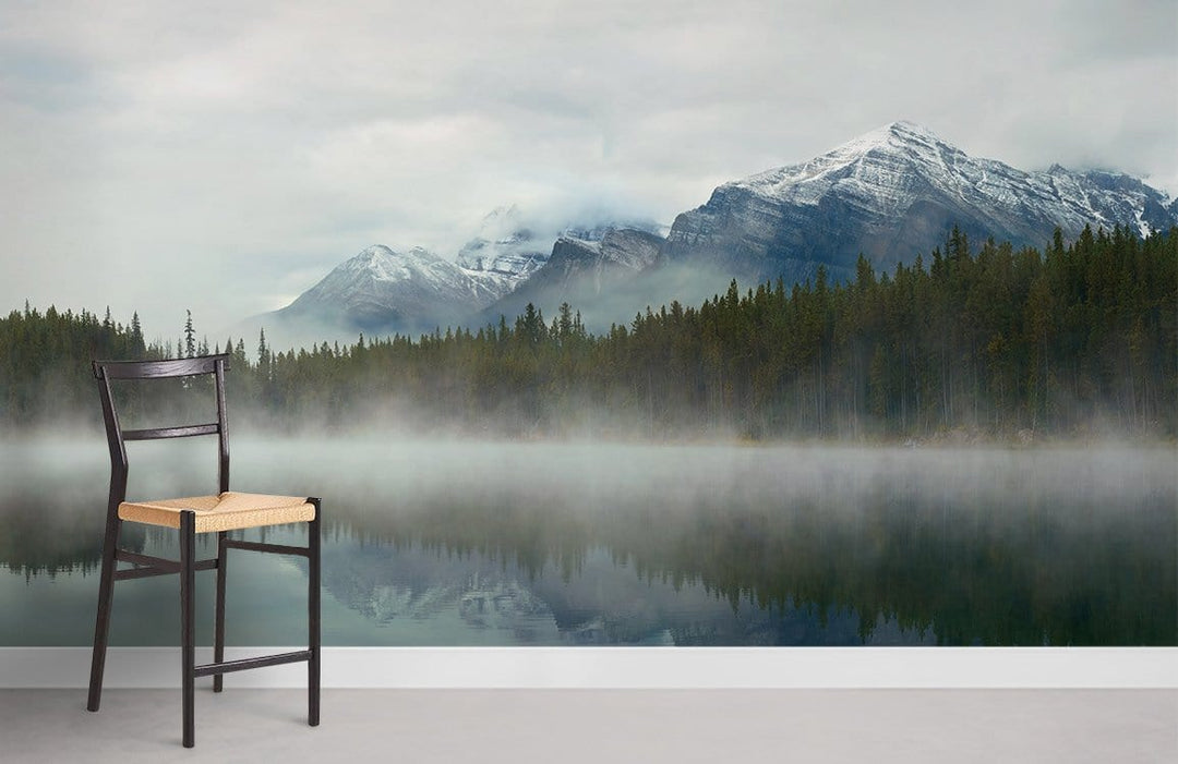 Tranquil green nature mural wallpaper with chair, misty lake, and mountains in serene room setting.