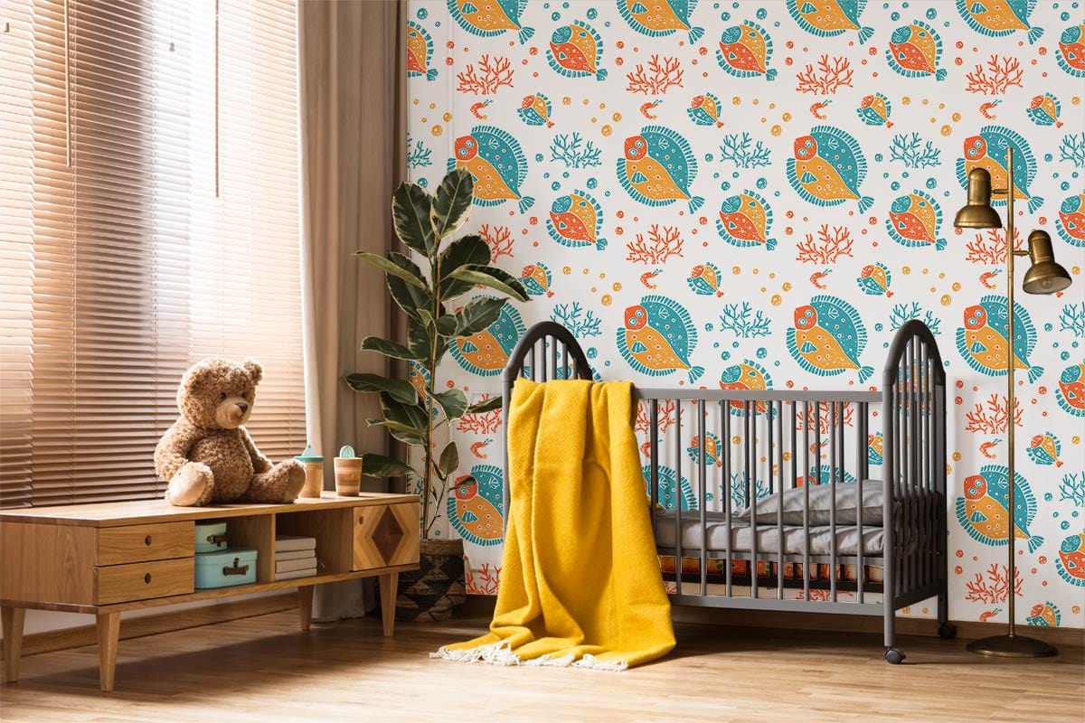 Vibrant undersea adventure wallpaper with orange and blue fish, grey cot, yellow throw, light wooden flooring.