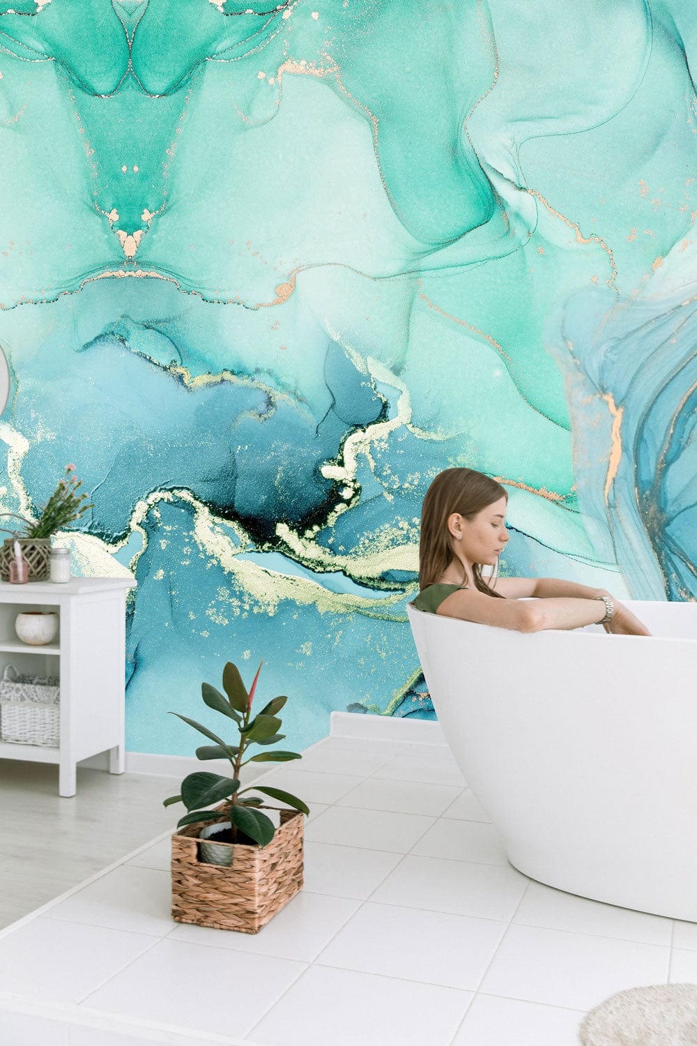 Turquoise marble effect mural wallpaper in bathroom with white bathtub, white tiles, decorative cabinet.