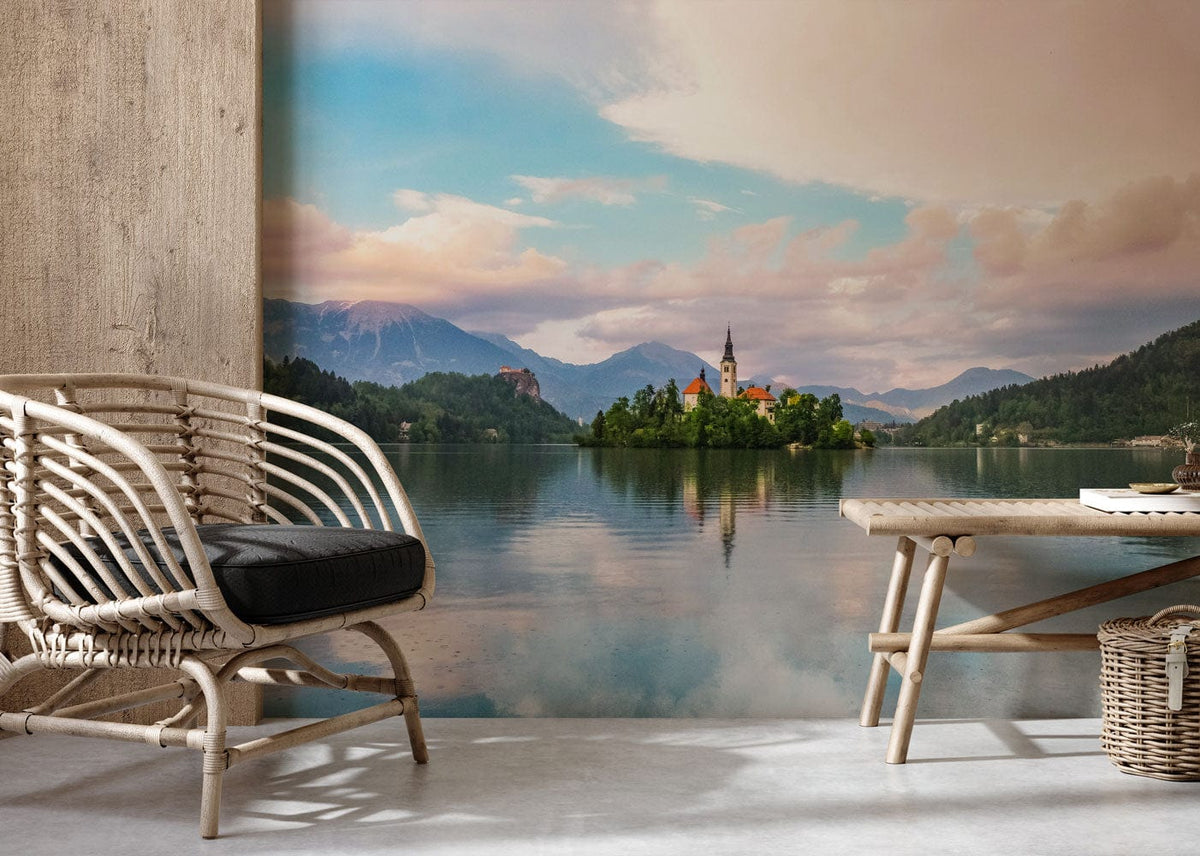 Tranquil mountain lake wallpaper with serene sunset hues, wicker chair, wooden table, concrete floor.