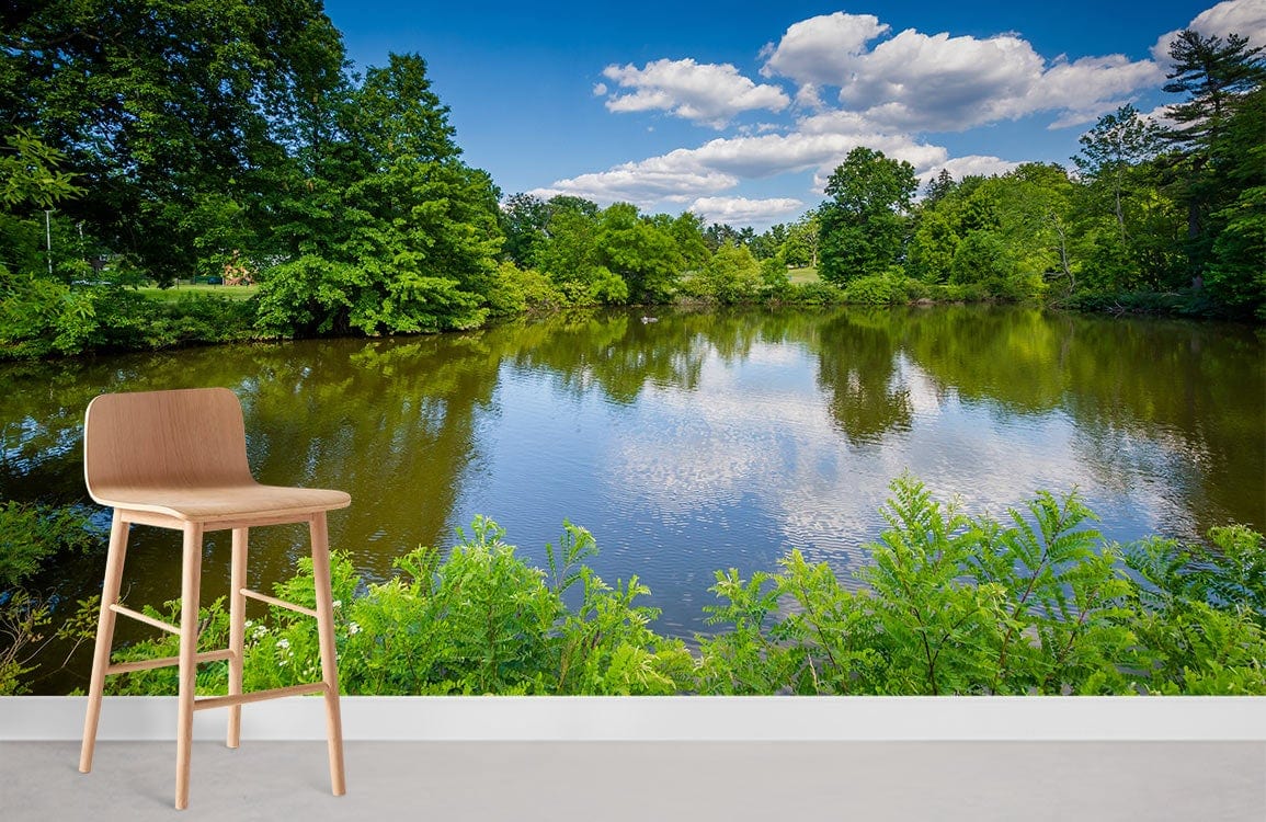 Tranquil lakeside mural wallpaper with natural scenery, featuring modern wooden stool, grey flooring, white wall.
