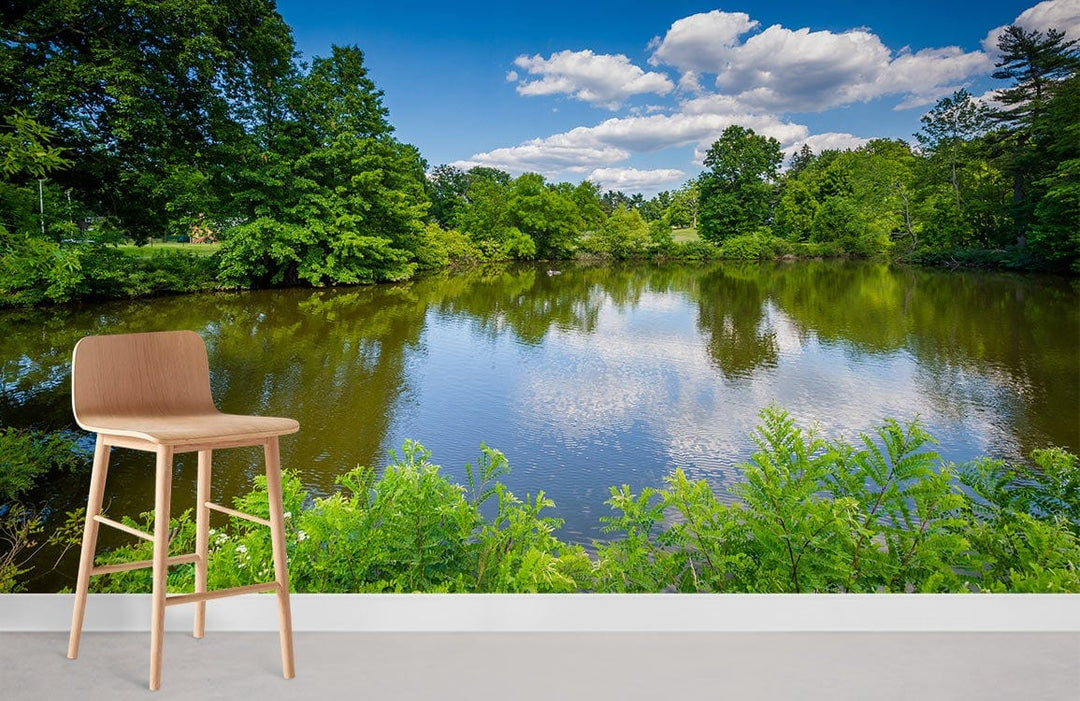 Tranquil lakeside mural wallpaper with natural scenery, featuring modern wooden stool, grey flooring, white wall.