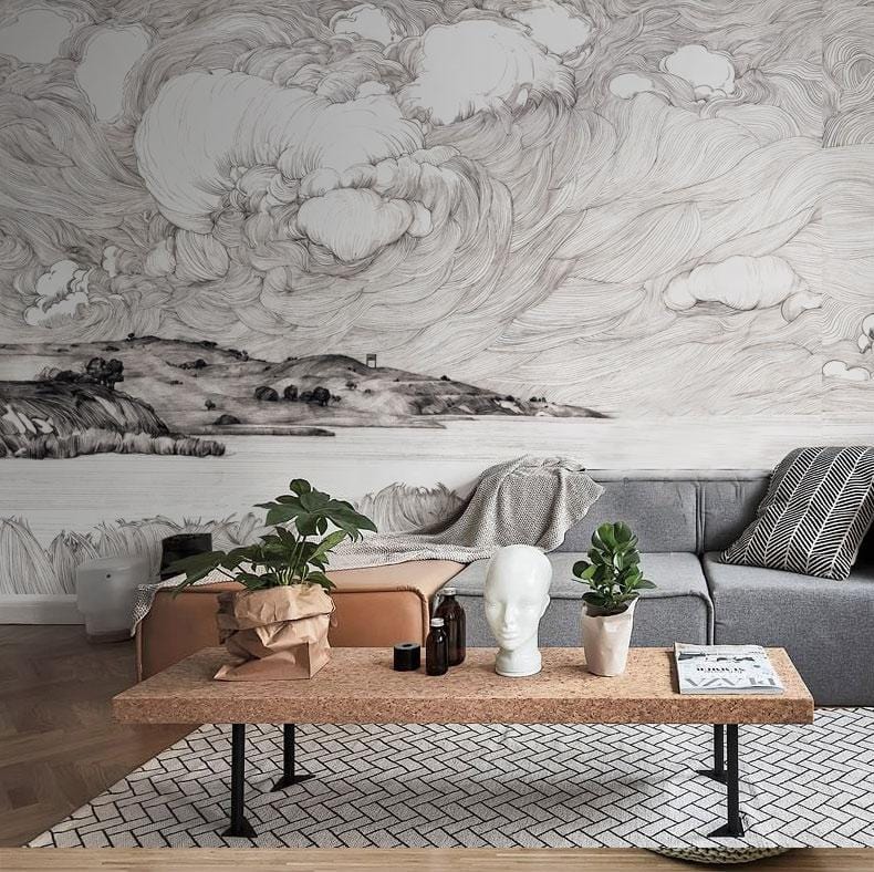 Monochrome coastal landscape mural wallpaper, grey sofa, wooden floor, geometric rug in modern living room.