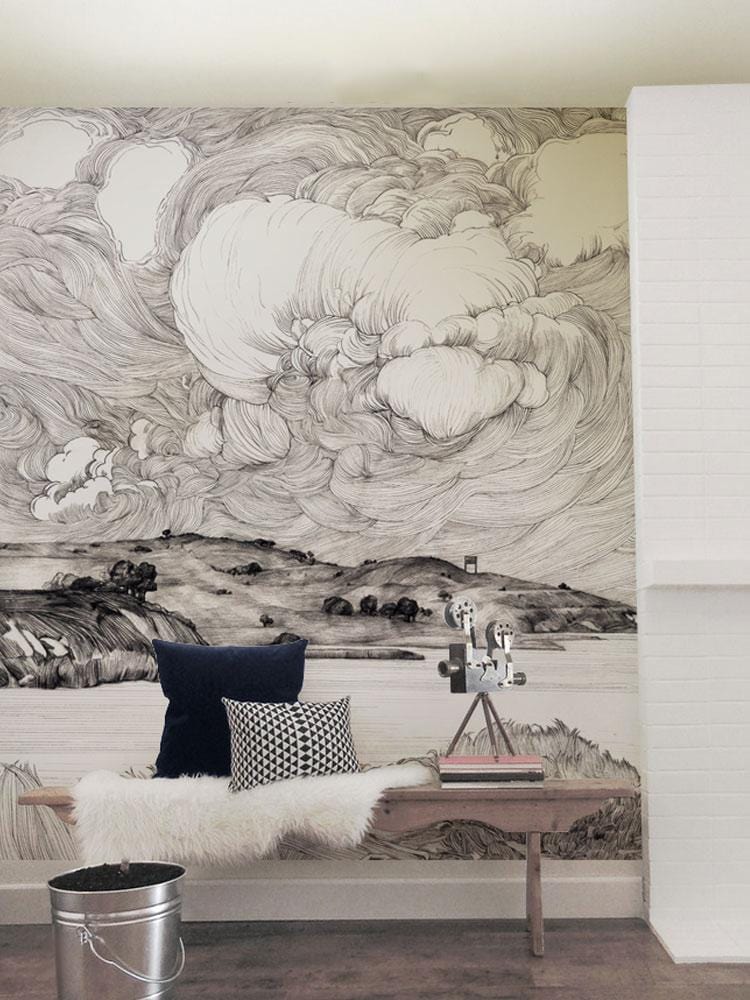 Monochrome Coastal Landscape Mural Wallpaper, artistic waves, hills design. Bench with cushions, wooden flooring.