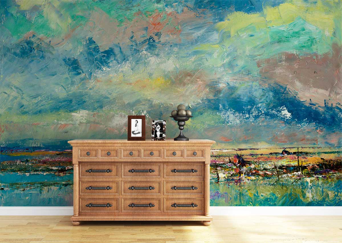 Abstract coastal mural wallpaper in vibrant blues and greens behind classic wooden chest, laminate flooring.