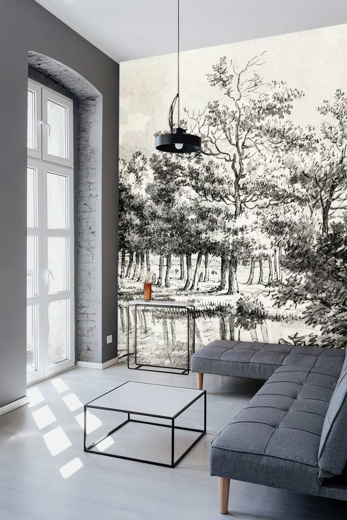 Vintage monochrome woodland wallpaper in modern grey living room with grey sofa, glass table, pendant light.