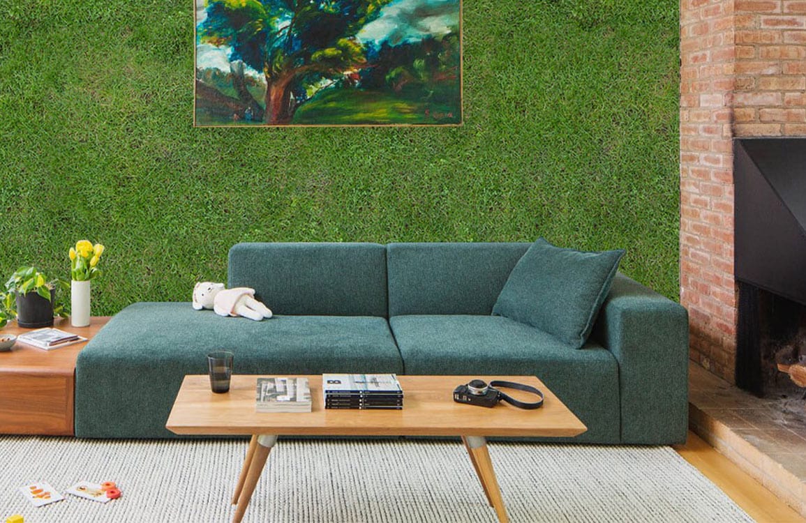 Green grass texture mural wallpaper, green sofa, brick wall, wooden floor, and abstract painting in living room.