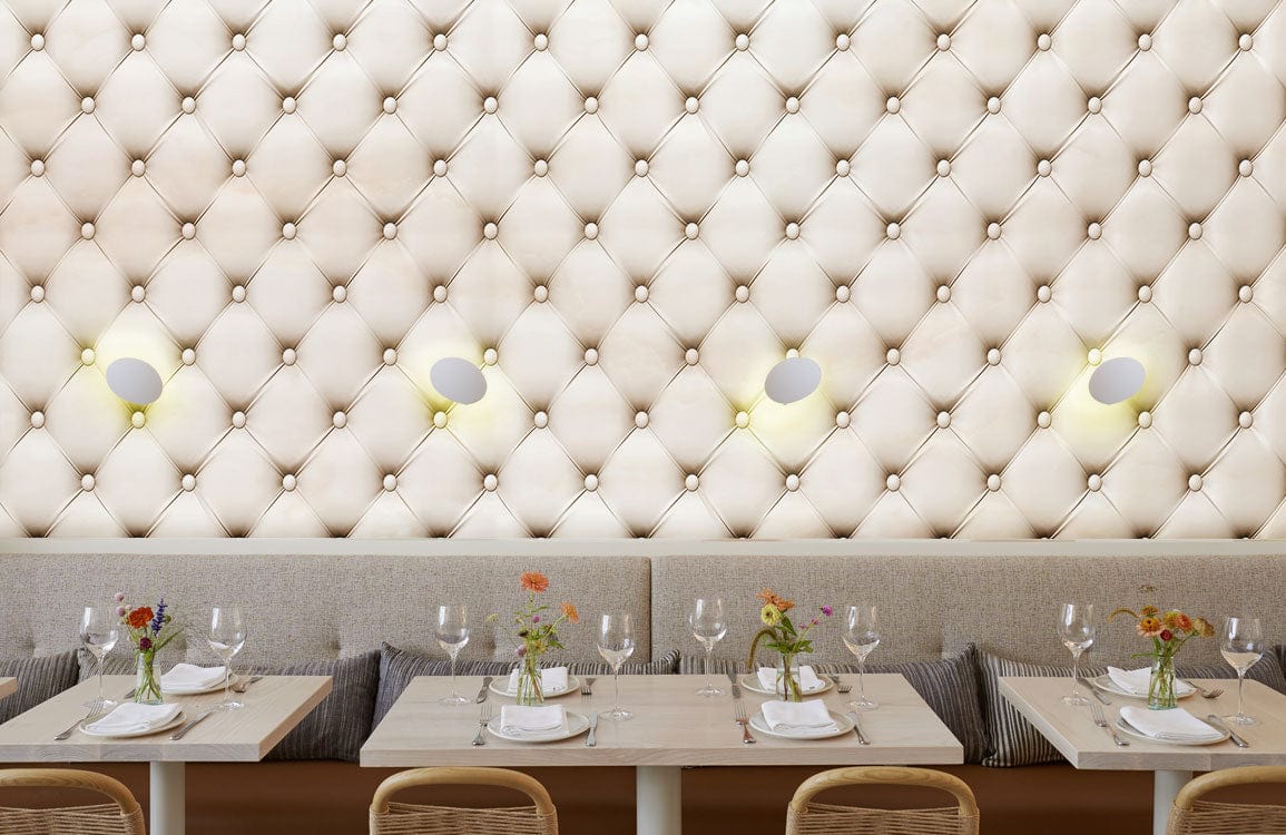 Luxurious quilted cream wallpaper in stylish dining room, elegant seating, sophisticated interior design.