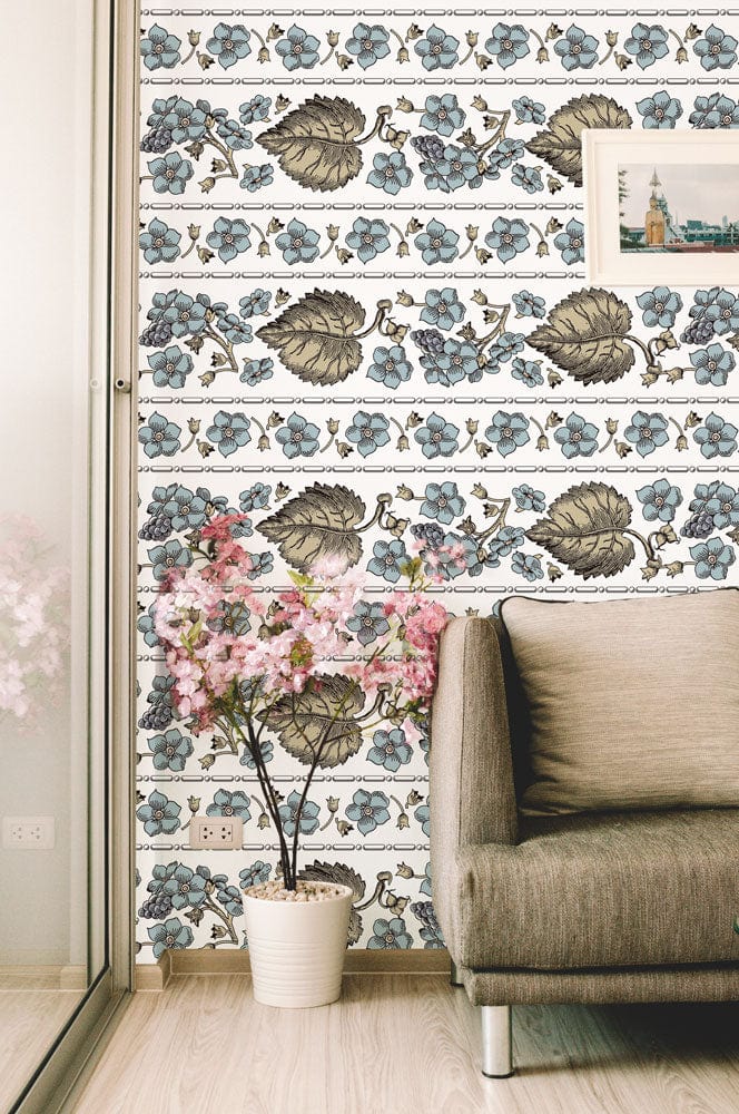 Vintage floral wallpaper in living room, beige sofa, light wood flooring, pink flower decor, framed artwork.