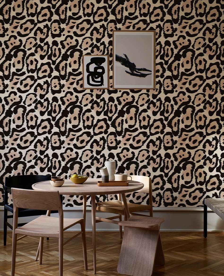 Elegant beige and black animal print wallpaper with wooden dining set and modern wall art.