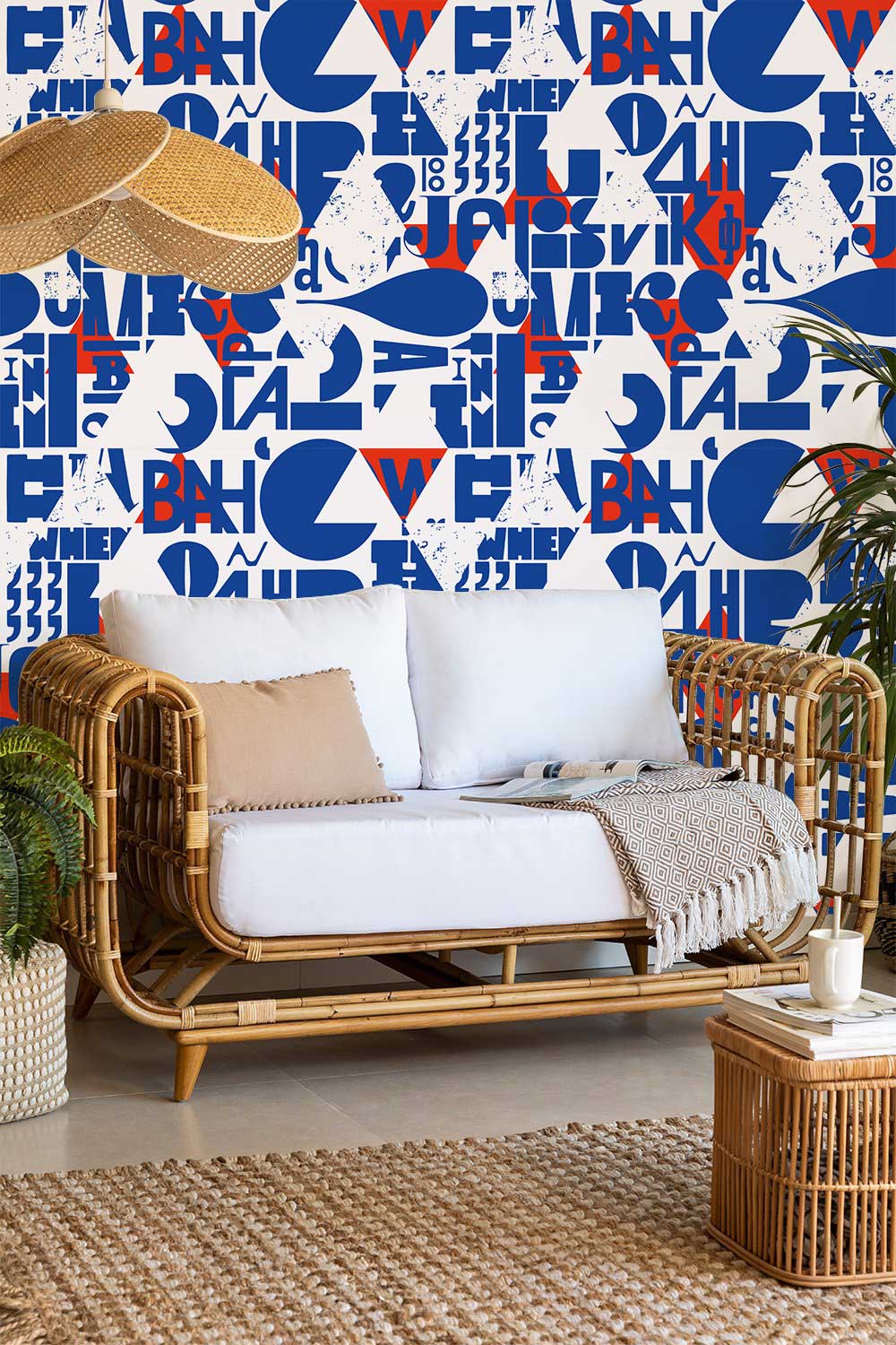 Contemporary blue and red geometric typography mural wallpaper with rattan sofa, wicker furniture, modern room.