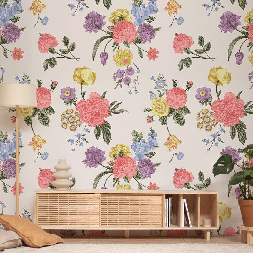 Vintage floral wallpaper in pastel multicolours; cosy cottage style with wooden sideboard and lamp.