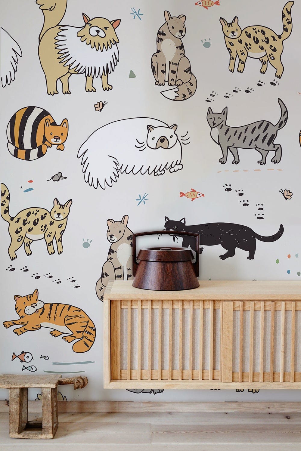 Decorative cat wallpaper in pastel tones for children's room, wooden furniture, light wood flooring.