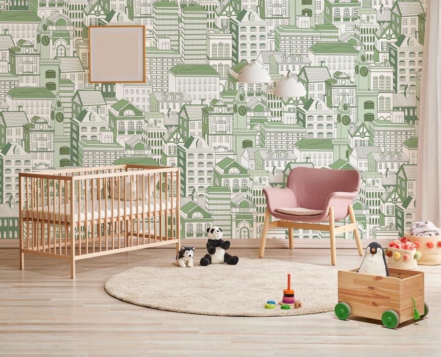 Nursery with green architectural wallpaper mural, wooden crib, pink accent chair, and light wood flooring.
