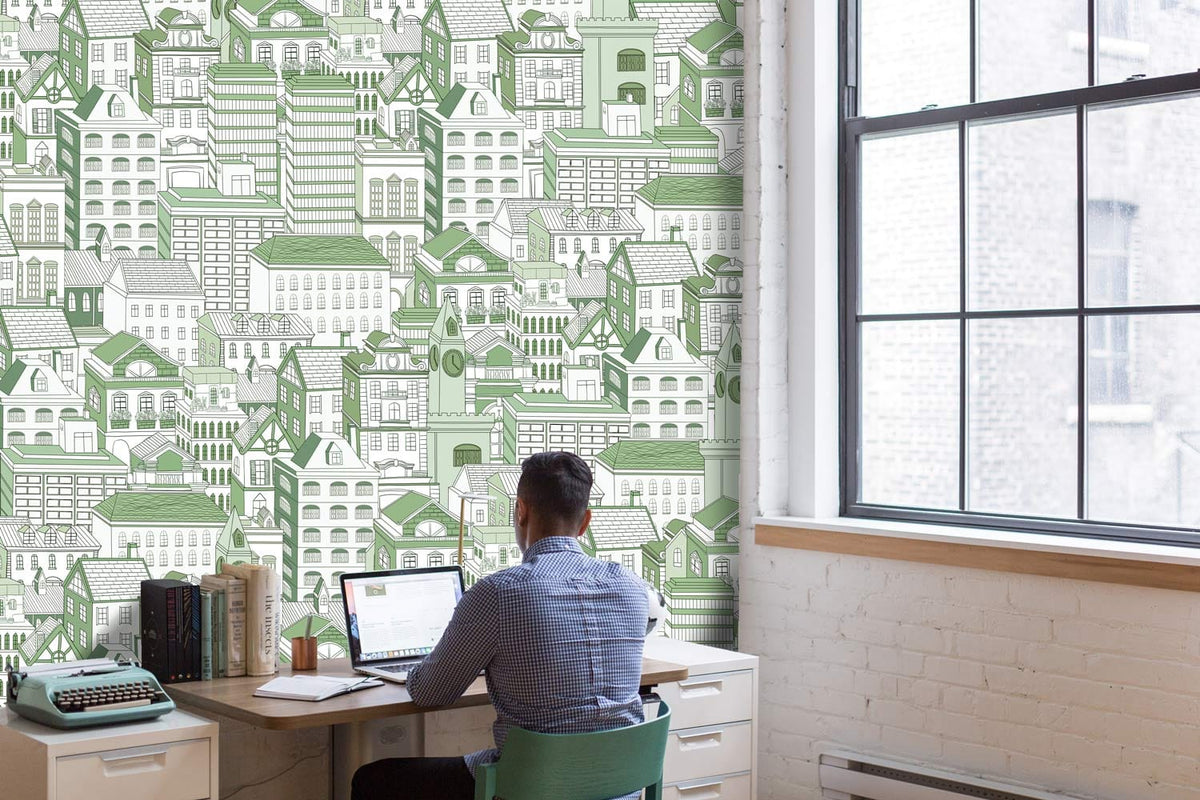 Green Urban Landscape Patterned Wallpaper in office with man working, white brick walls, large window.
