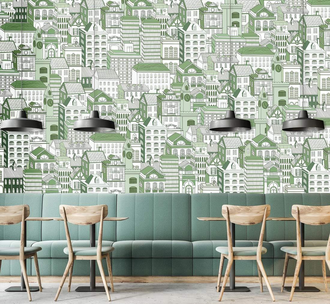 Green urban landscape patterned wallpaper mural in cafe, with teal sofa and wooden chairs.