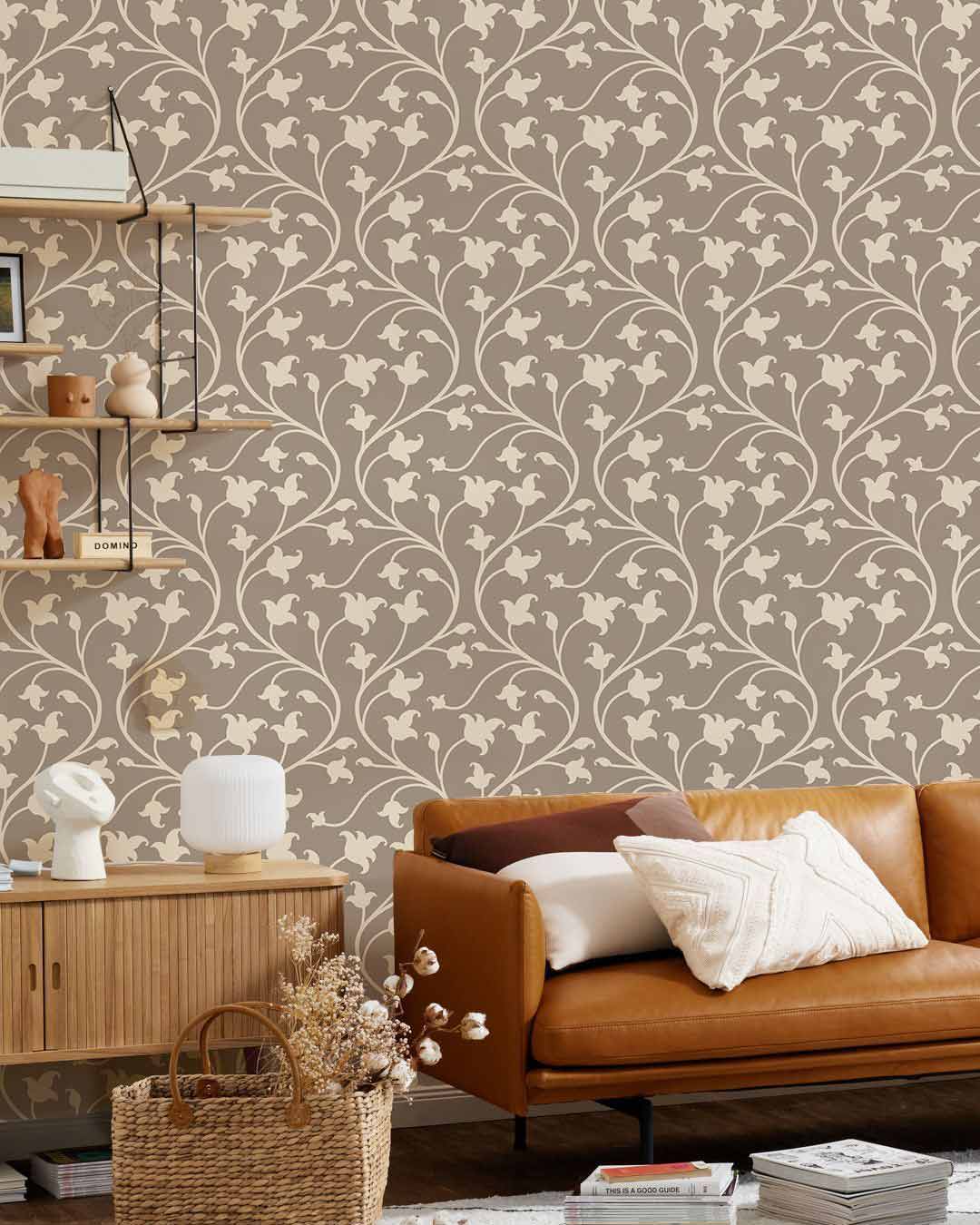Elegant taupe floral wallpaper with vintage decor, brown leather sofa, and wooden furniture in living room.