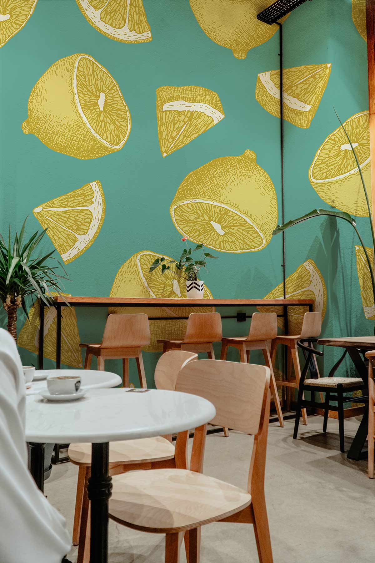 Vintage Lemon Pattern Wallpaper in teal, yellow, café setting, wooden chairs, white tables. Kitchen decor.