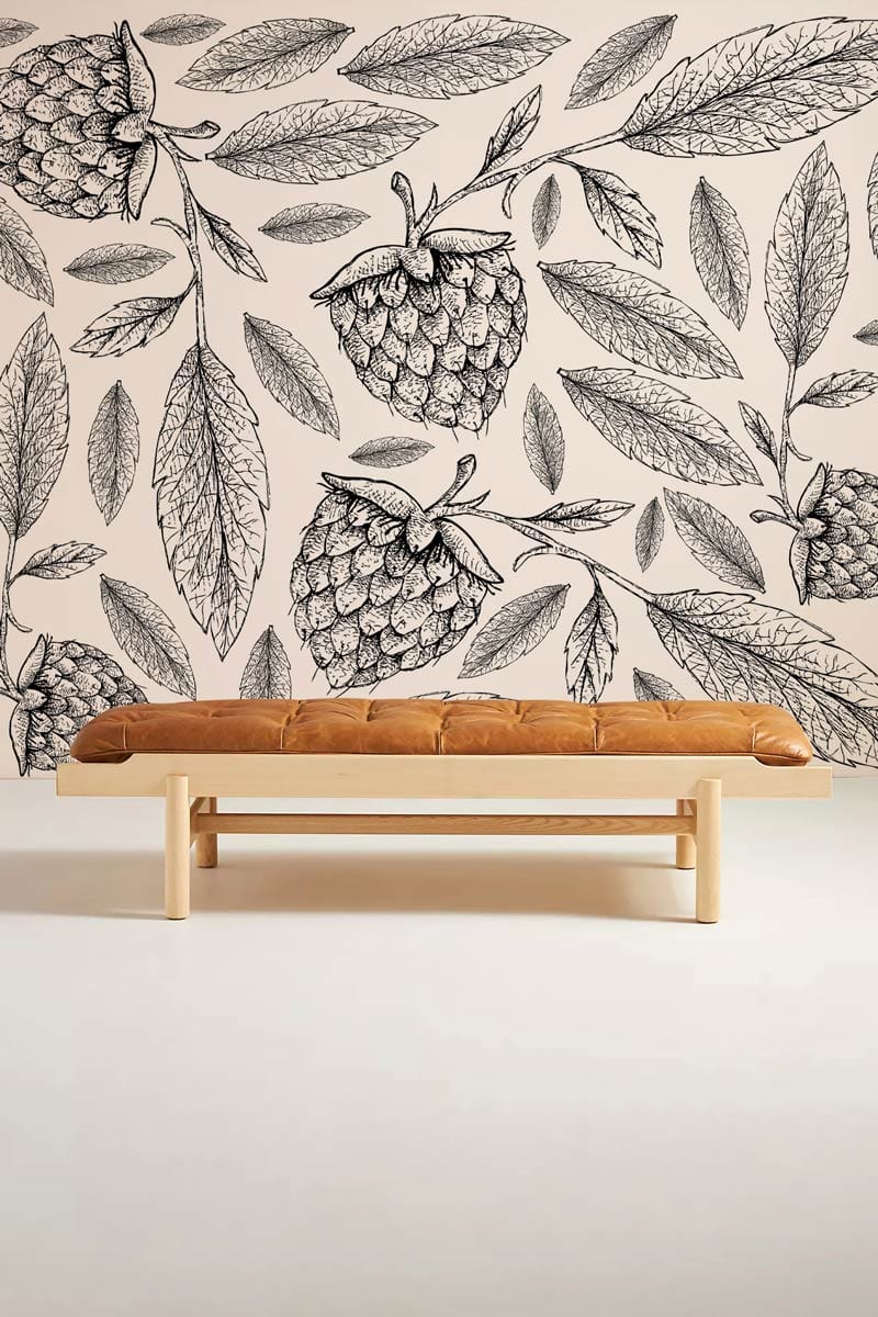 Monochrome botanical berry sketch wallpaper with tan bench enhances elegant interior styling.