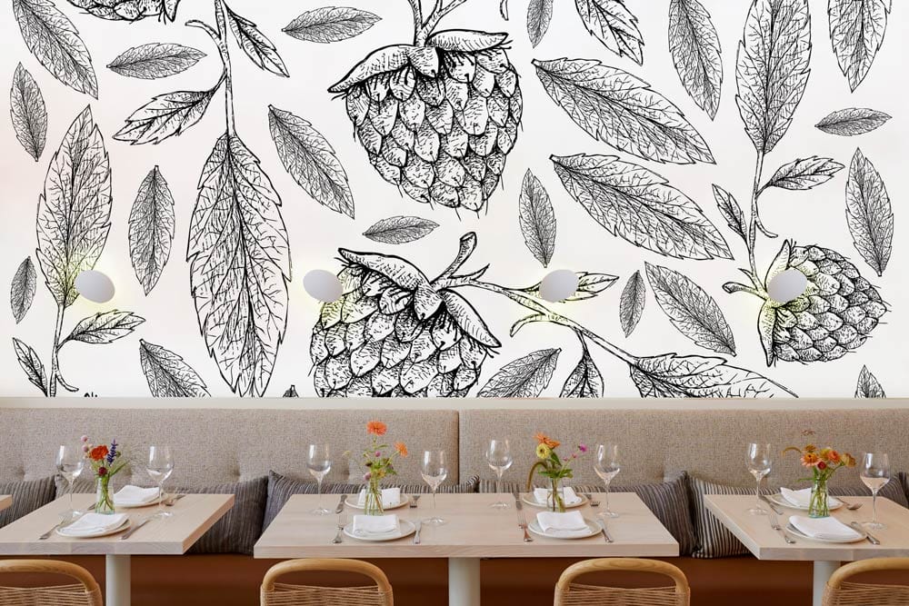 Monochrome botanical berry sketch wallpaper, café seating, rattan chairs, contemporary dining space, elegant decor.