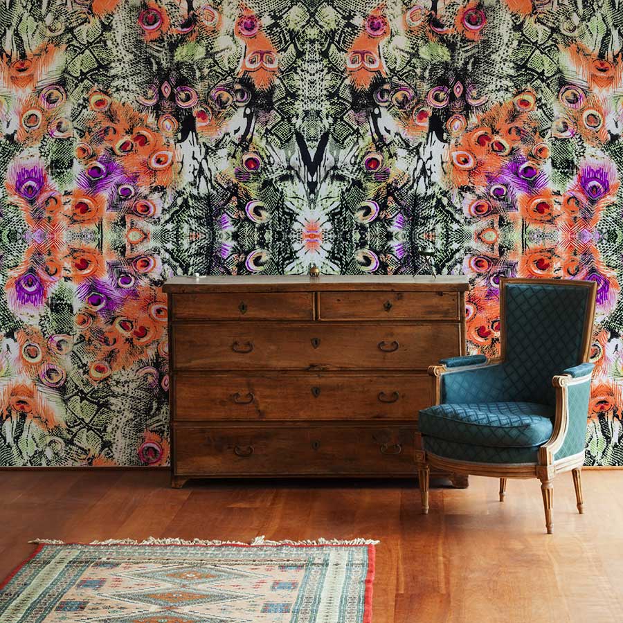 Exotic Jungle Kaleidoscope Wallpaper, vibrant pattern, wooden dresser, blue chair, wooden flooring, rug.