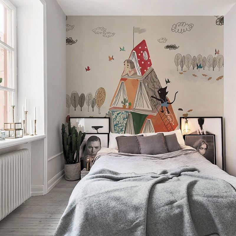 Children's room with Whimsical Autumn Adventure mural wallpaper, grey sofa, wooden flooring, soft earthy colours.