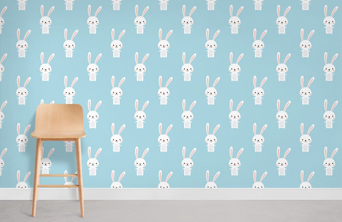 Charming Pastel Blue Bunny Wallpaper for Kids' Room with Wooden Stool and Grey Flooring.