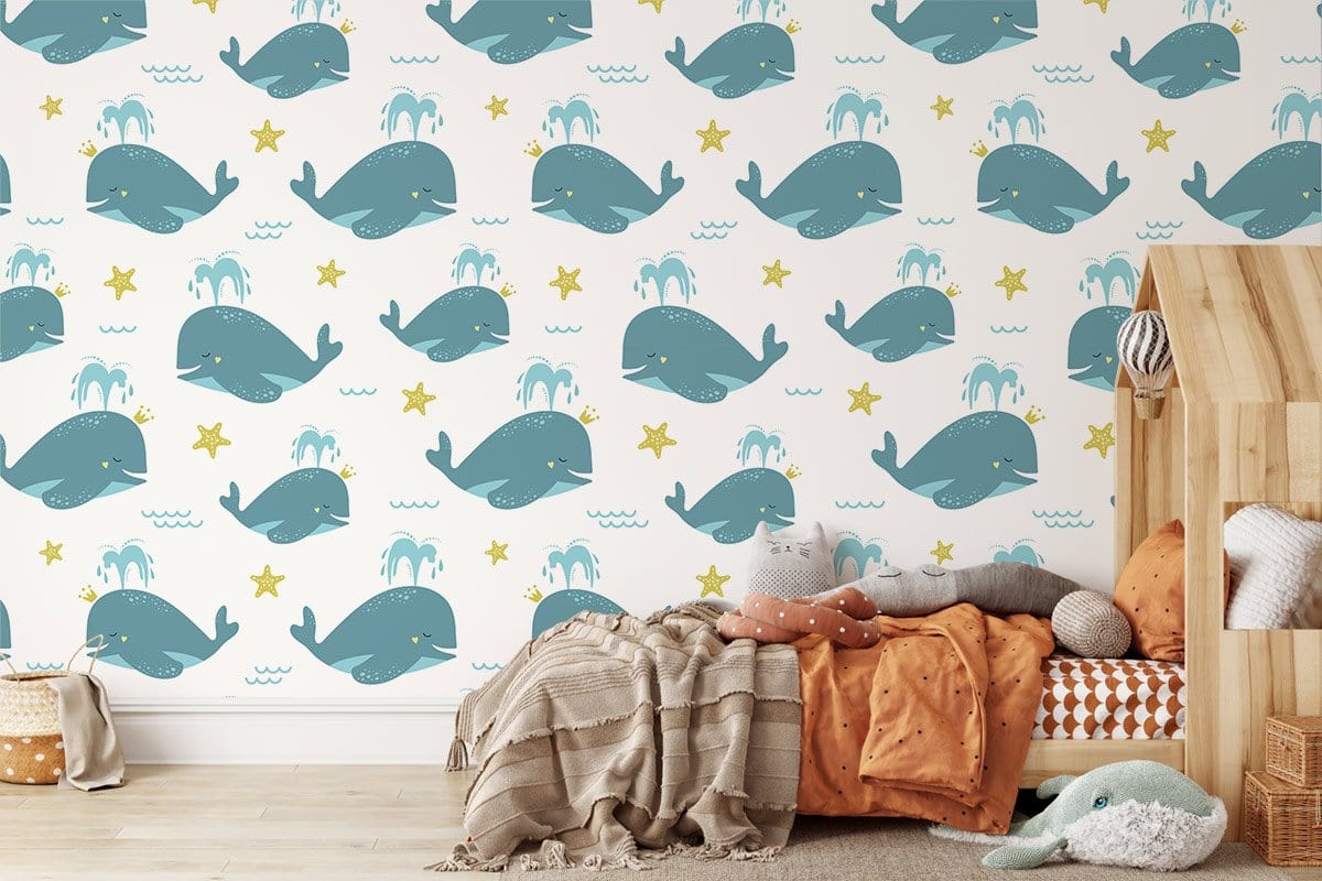 Playful Blue Whale children's wallpaper with nautical theme in cosy nursery, wooden flooring, colourful bedding.