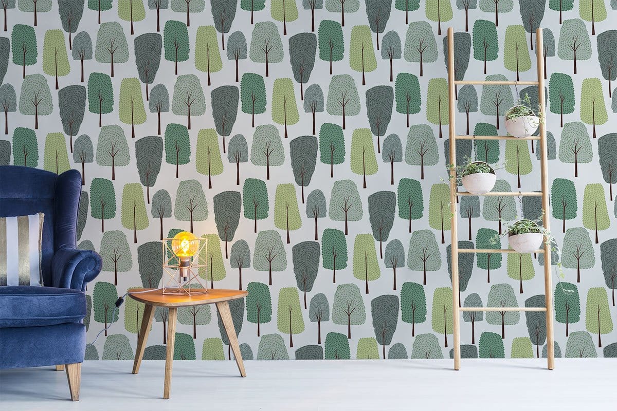 Green Scandinavian forest wallpaper with blue velvet sofa, wooden ladder, light wood flooring, nature-inspired design.