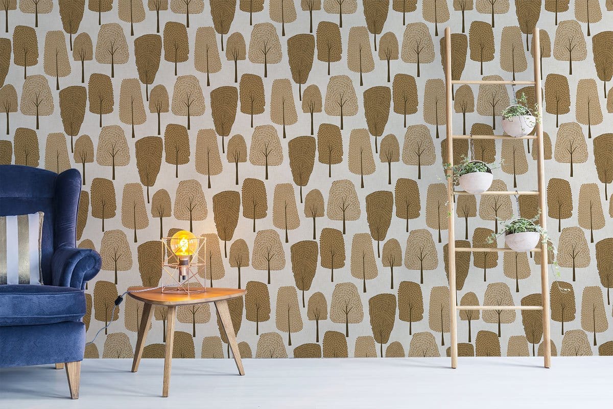 Rustic Woodland Tree Wallpaper in brown tones, blue velvet sofa, light wood flooring, modern decor.