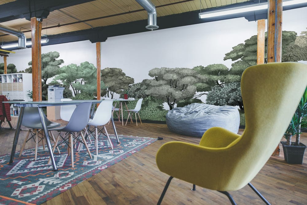 Open-plan room with Serene Forest Green Canopy Mural, yellow chair, wooden flooring, and patterned rug.