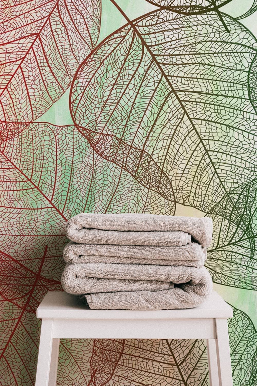 Autumn Leaf Wallpaper, nature-inspired red and green design, beige towels on white chair.