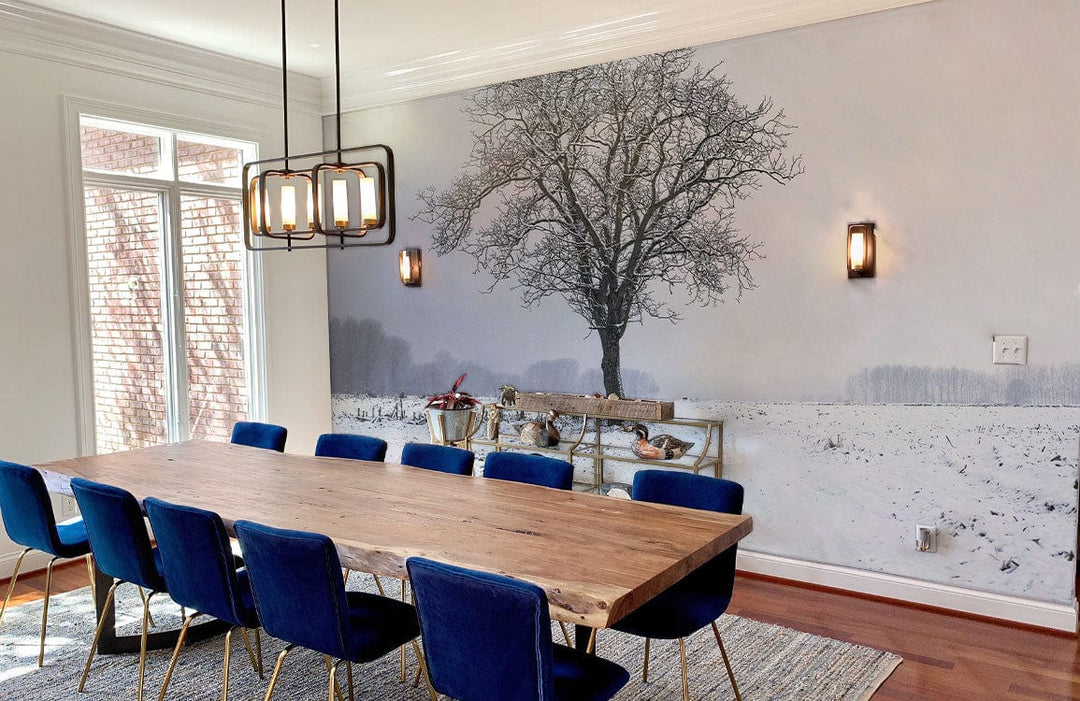 Winter Solitude Mural Wallpaper in dining room with blue chairs, wooden table, hardwood flooring, dimensions visible.