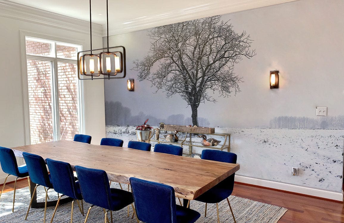 Winter Solitude Mural Wallpaper in dining room with blue chairs, wooden table, hardwood flooring, dimensions visible.