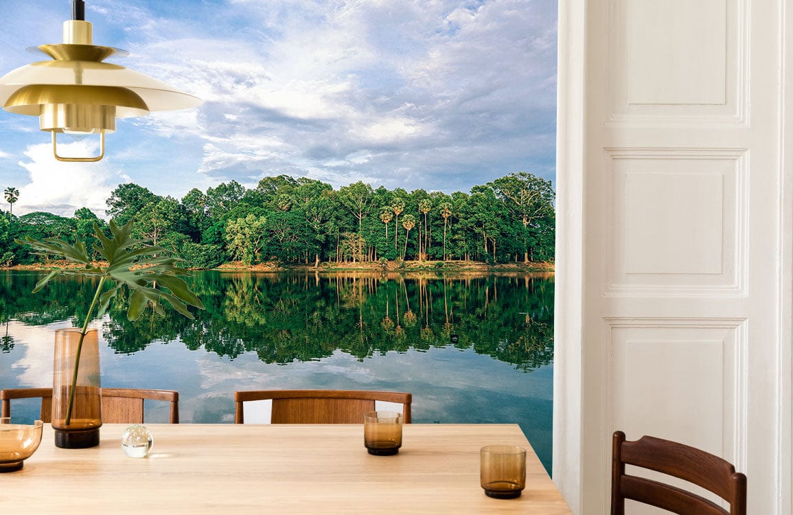 Dining room with Serene Lakeside Forest mural wallpaper; wooden chairs, table, white panelled wall.
