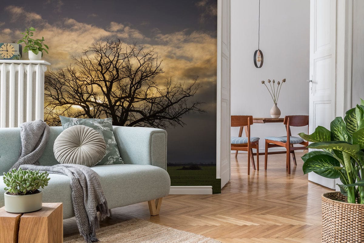Solitary Tree Mural Wallpaper in warm tones with grey sofa, herringbone flooring, and dining table.