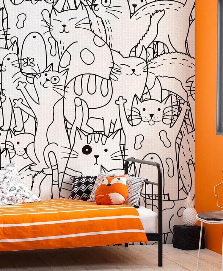 Monochrome cats wallpaper in bedroom, with black bedframe, orange bedding, and wooden flooring.