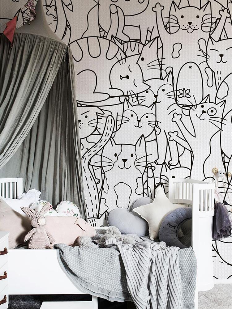 Monochrome cats wallpaper in whimsical nursery, featuring grey canopy and modern white crib.