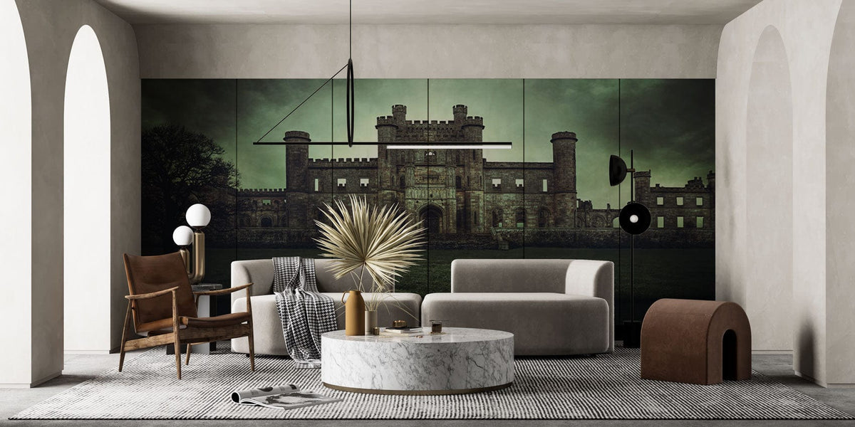 Gothic Castle mural in moody green tones; grey sofa, marble table; elegant living room design.