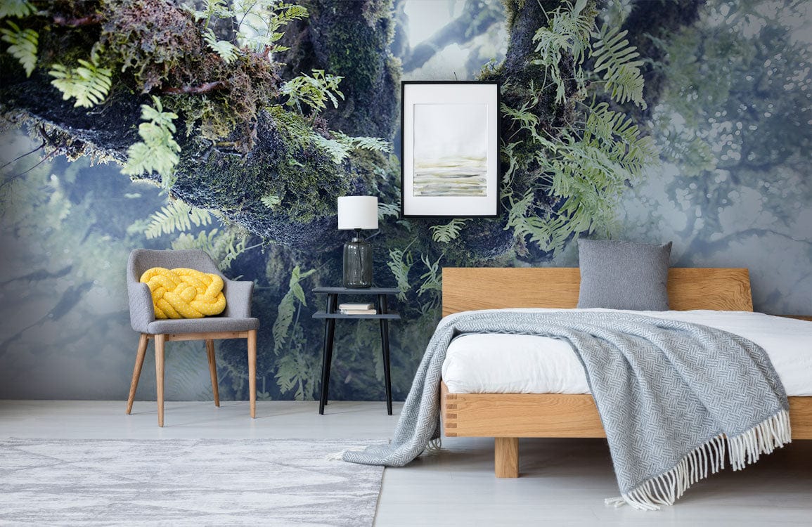 Botanical Forest Canopy Mural Wallpaper with wood bed, grey armchair, and lush green-blue theme.