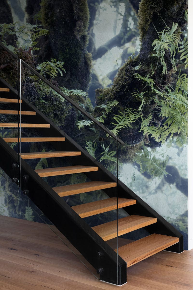 Botanical Forest Canopy mural wallpaper in lush green; wooden staircase; glass railing; wooden flooring.