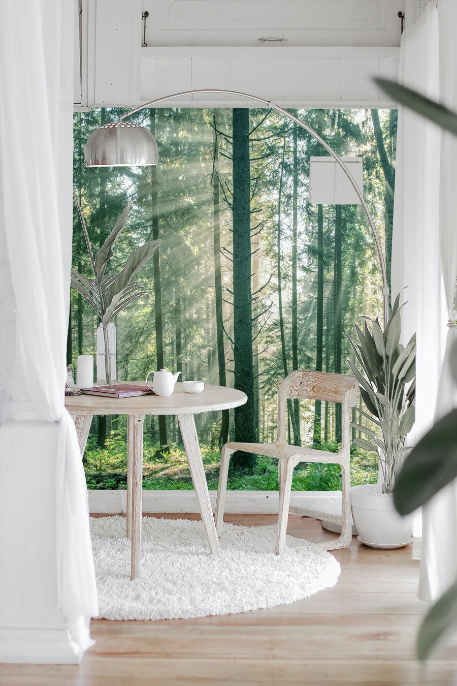 Sunlit Forest Mural wallpaper with serene woodland escape; features wooden chair, round table, rug, white walls.