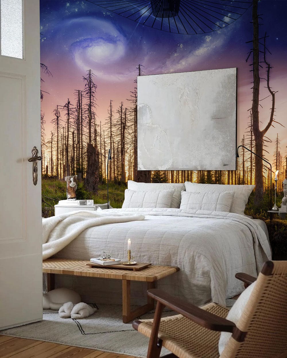 Mystical Galaxy Forest Sunset Mural Wallpaper in bedroom with white bedding, wicker chair, and wooden bench.