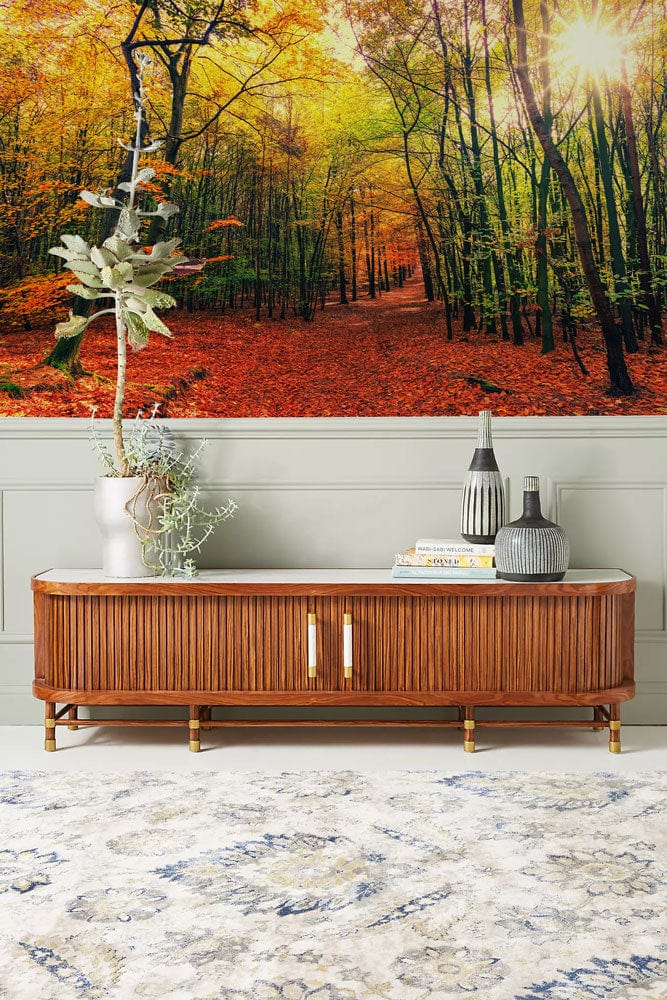 Enchanting Autumn Forest Path Mural Wallpaper, wooden sideboard, light patterned rug, and elegant vases.
