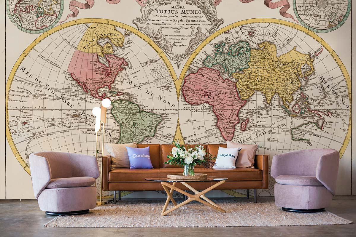 Vintage World Map Mural Wallpaper in antique colours; brown leather sofa, cosy chairs, hardwood flooring.