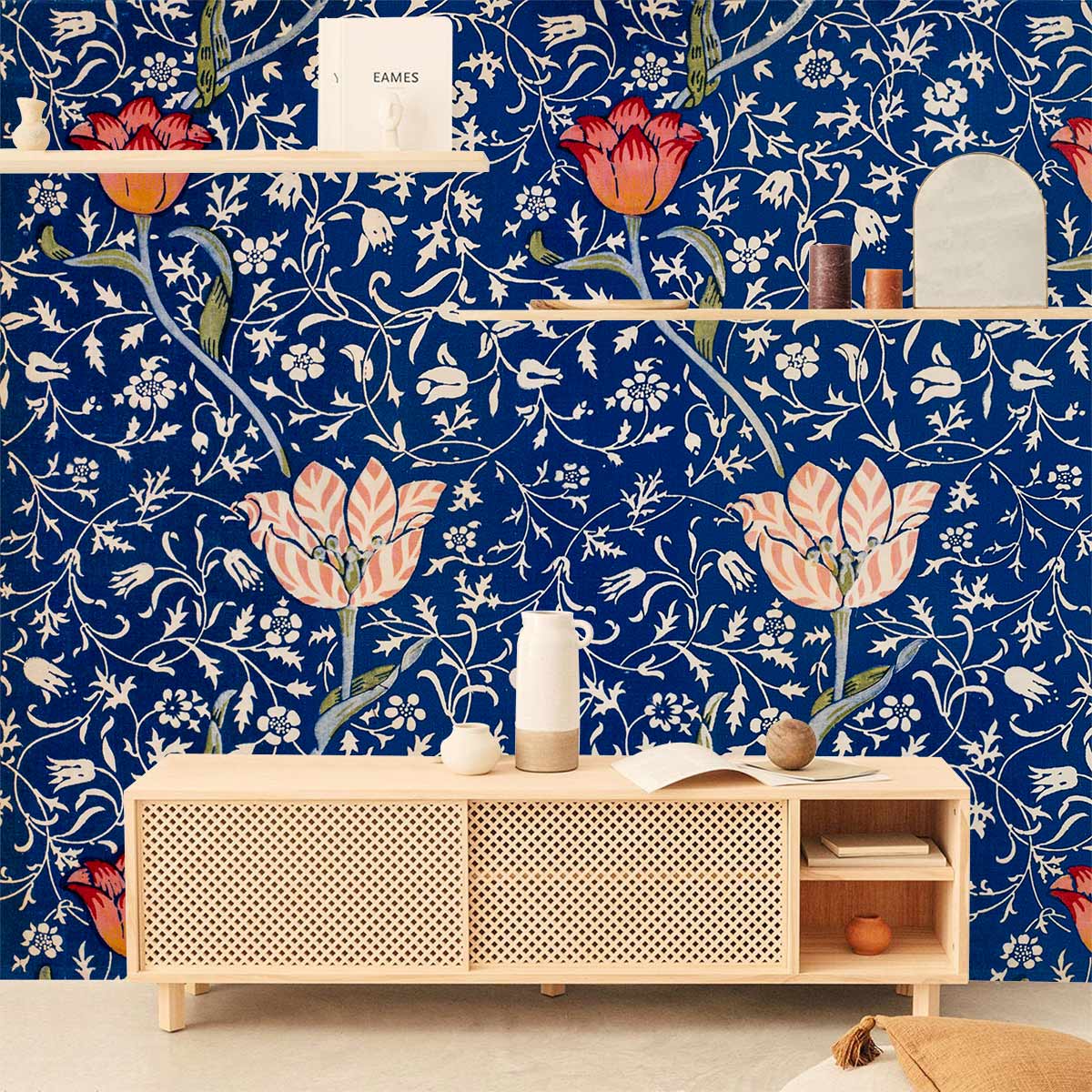 Vintage floral blue and red botanical wallpaper with Art Nouveau pattern behind modern wooden sideboard.