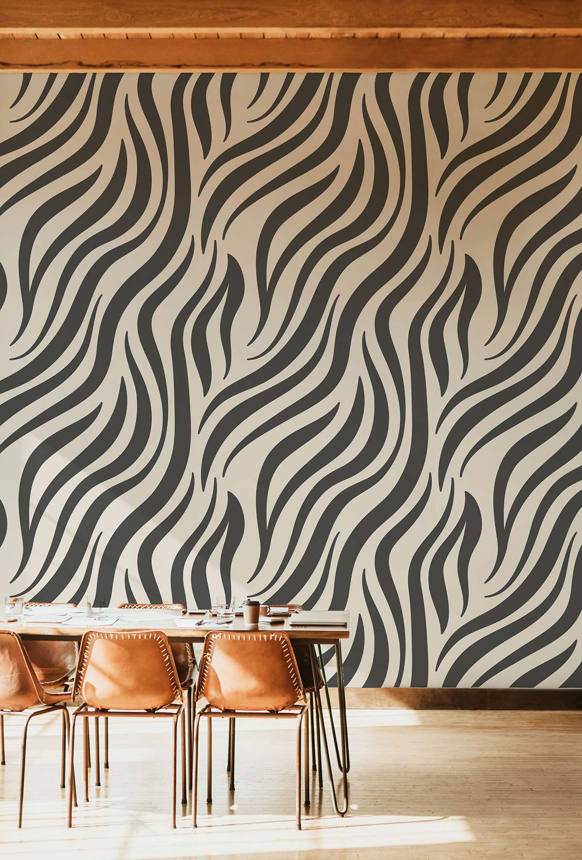 Monochrome zebra stripe wallpaper in modern room with brown leather chairs and light wooden flooring.