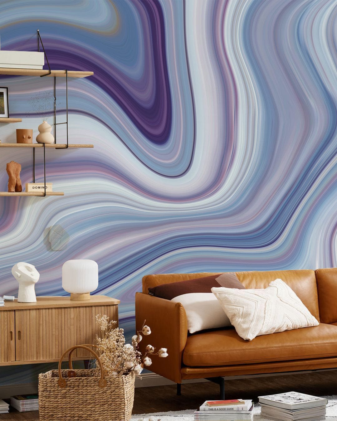 Elegant swirling marble wallpaper mural, blue-purple abstract, brown leather sofa, wooden cabinet, shelves.