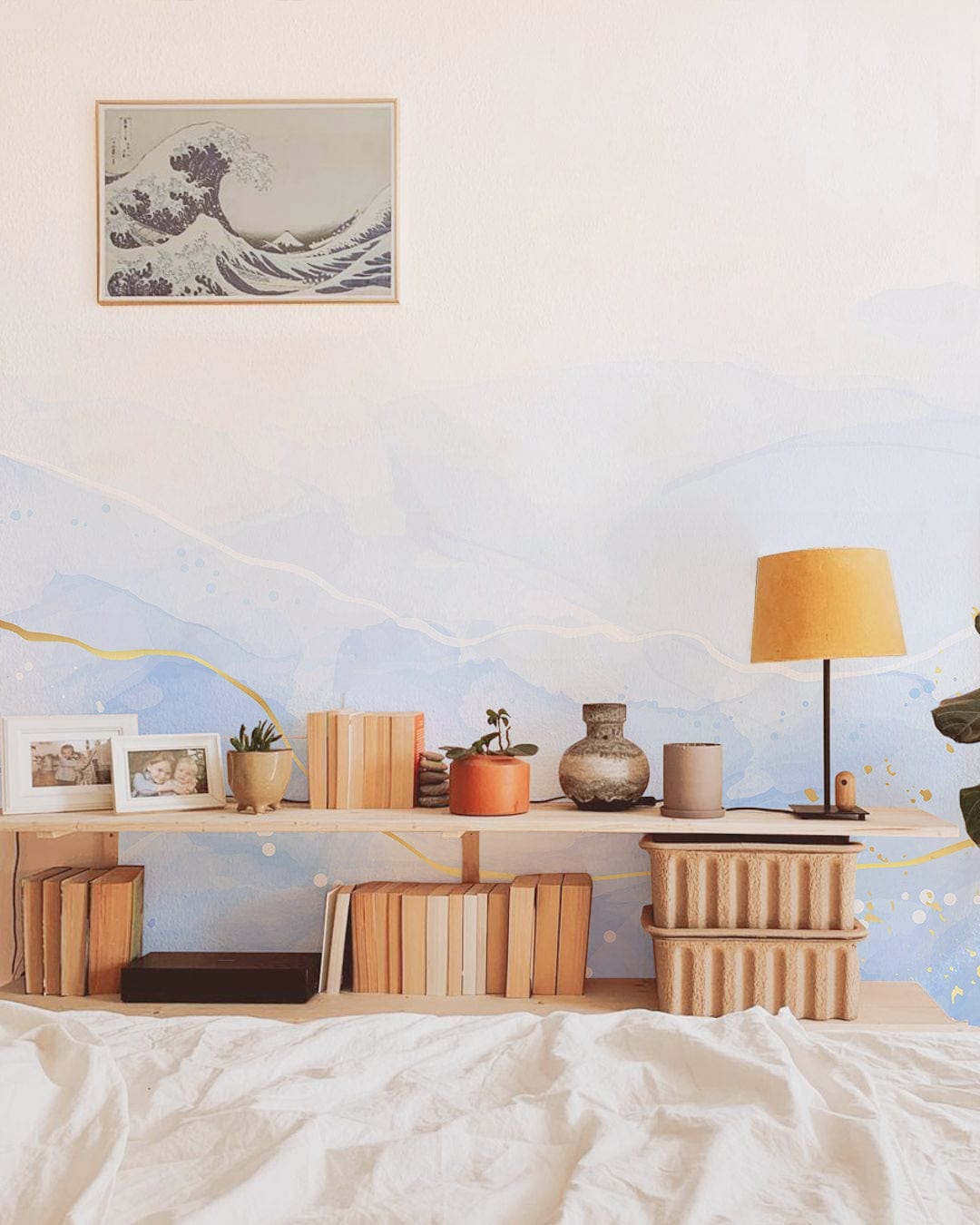 Elegant abstract blue and gold mural wallpaper in modern bedroom with artwork, lamp, and decor.