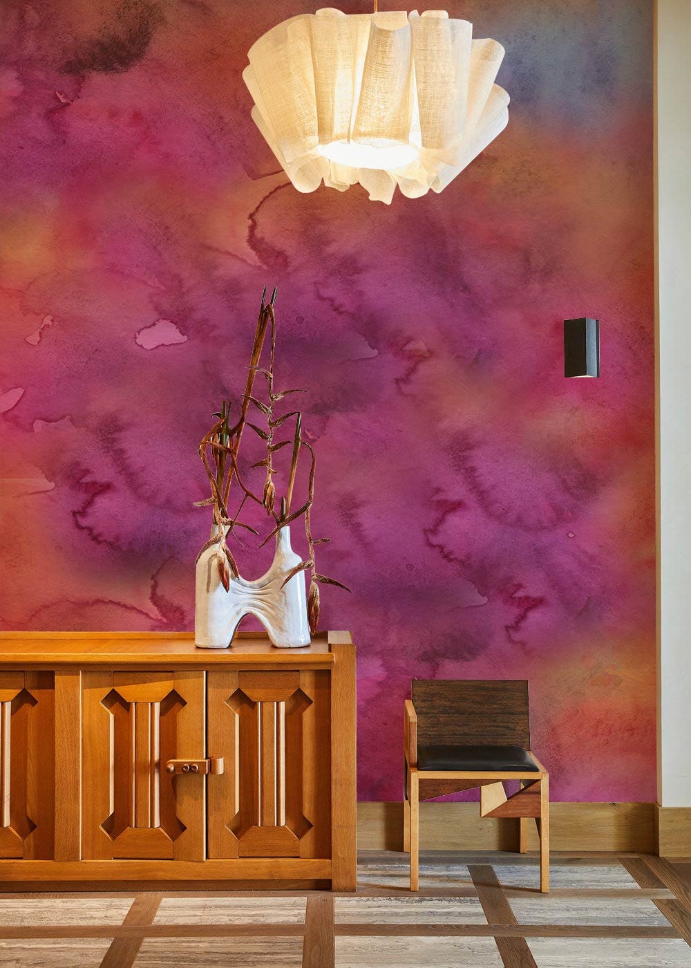 Vibrant watercolour floral mural wallpaper with wooden sideboard, modern chair, pendant light in living room.